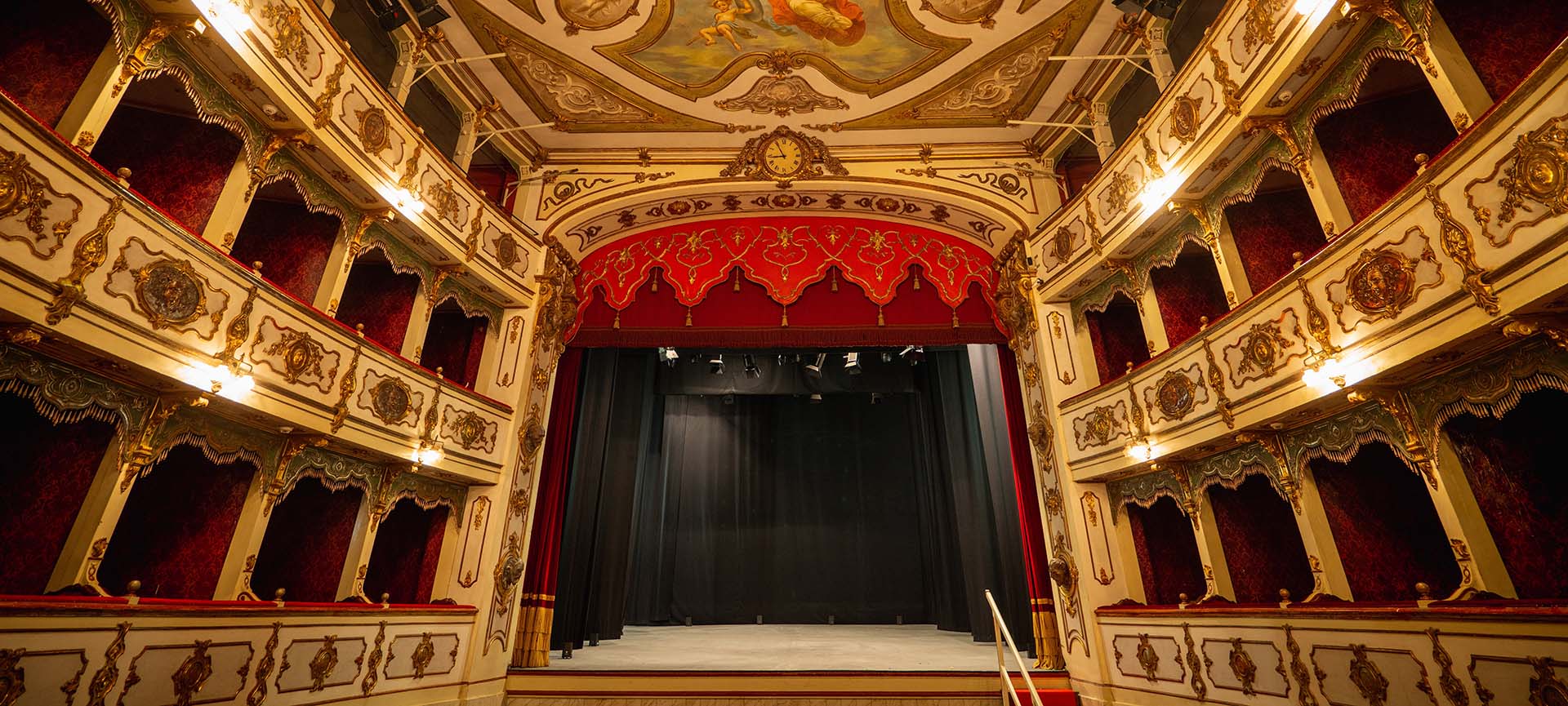 The interior of a theater featuring ornate walls and an elegant chandelier, showcasing a luxurious ambiance.